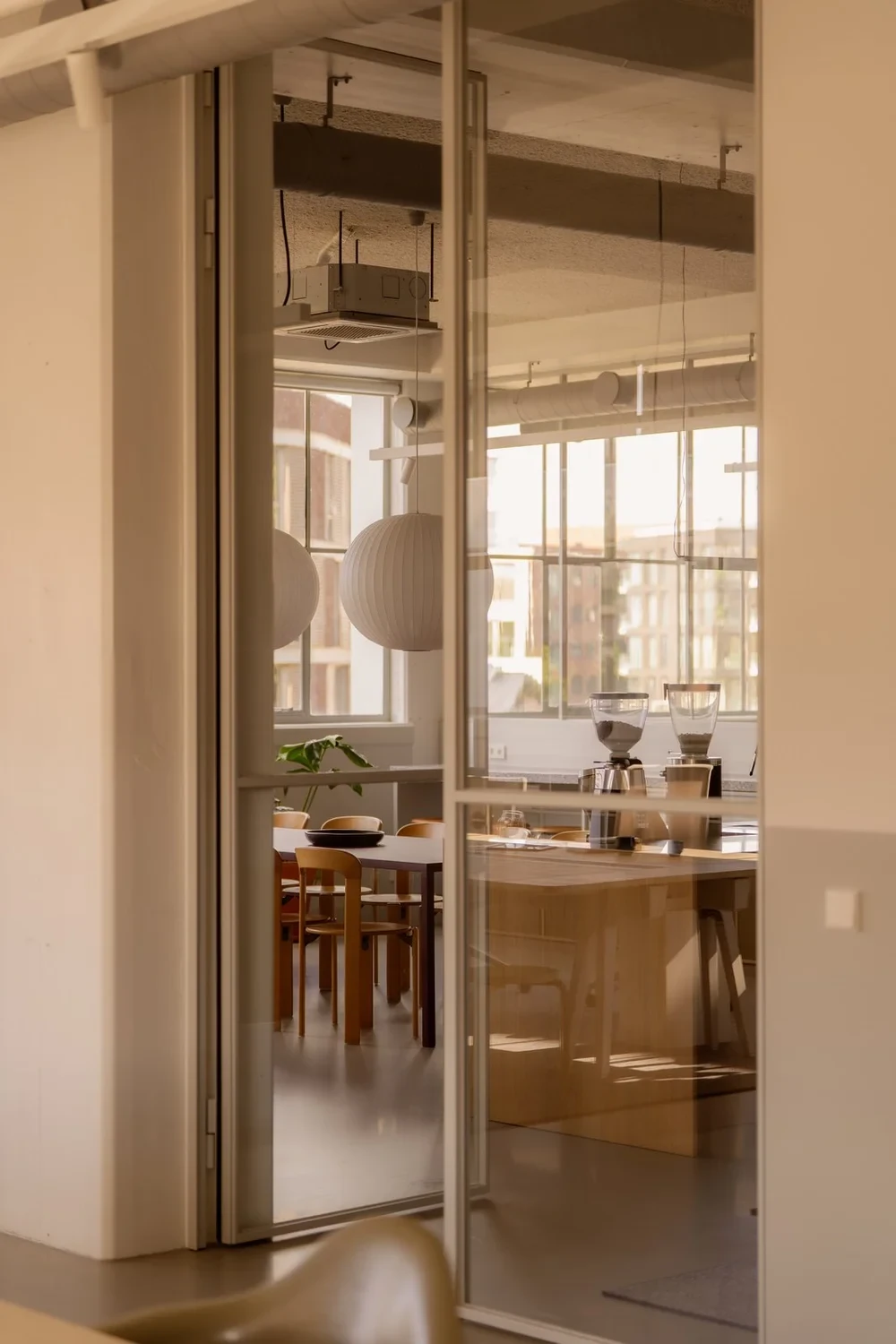 Glazen deur met slank frame naast de werkplekken